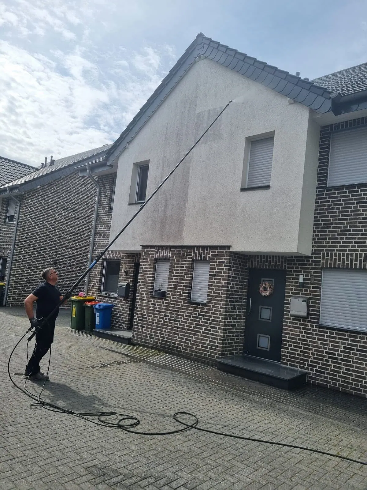Fassadenreinigung mit Teleskoplanze an einem Reihenhaus mit Klinkersockel