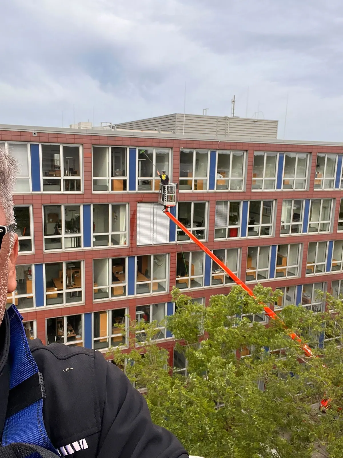 Arbeitsbühne an der Fassade eines mehrgeschossigen Gewerbegebäudes