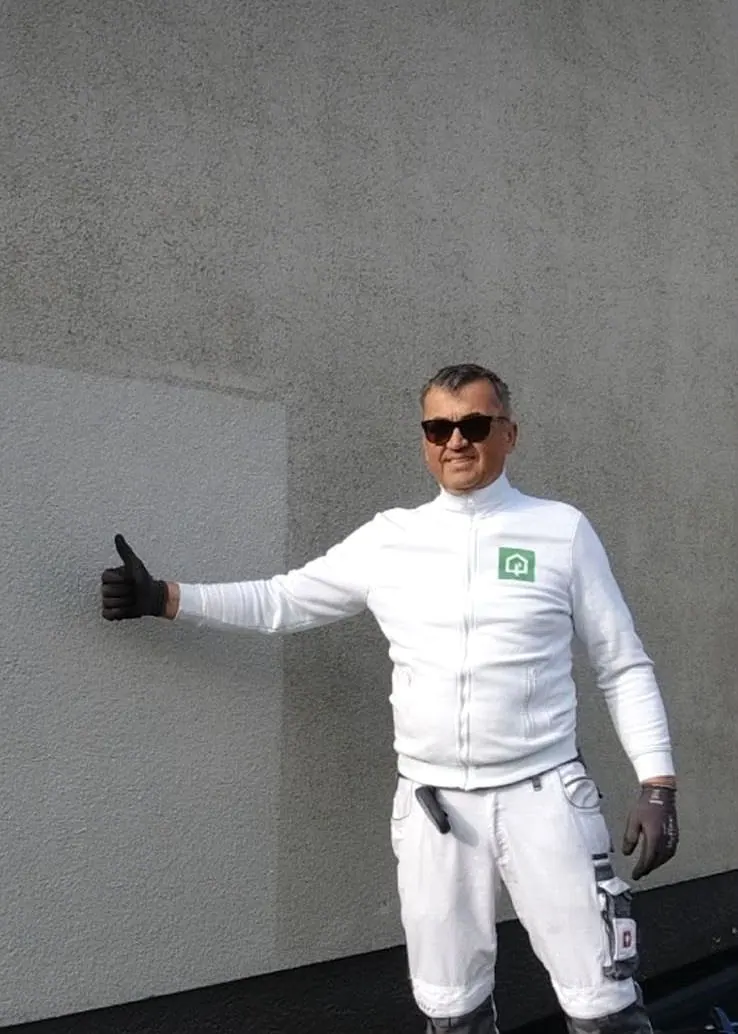 Sakic Smajo, Inhaber von GreenTech Solutions, in Arbeitskleidung vor einer gereinigten Fassadenfläche